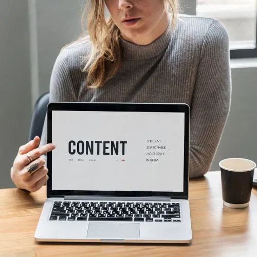 Ordinateur avec un page ouverte et une personne montrant l'écran.